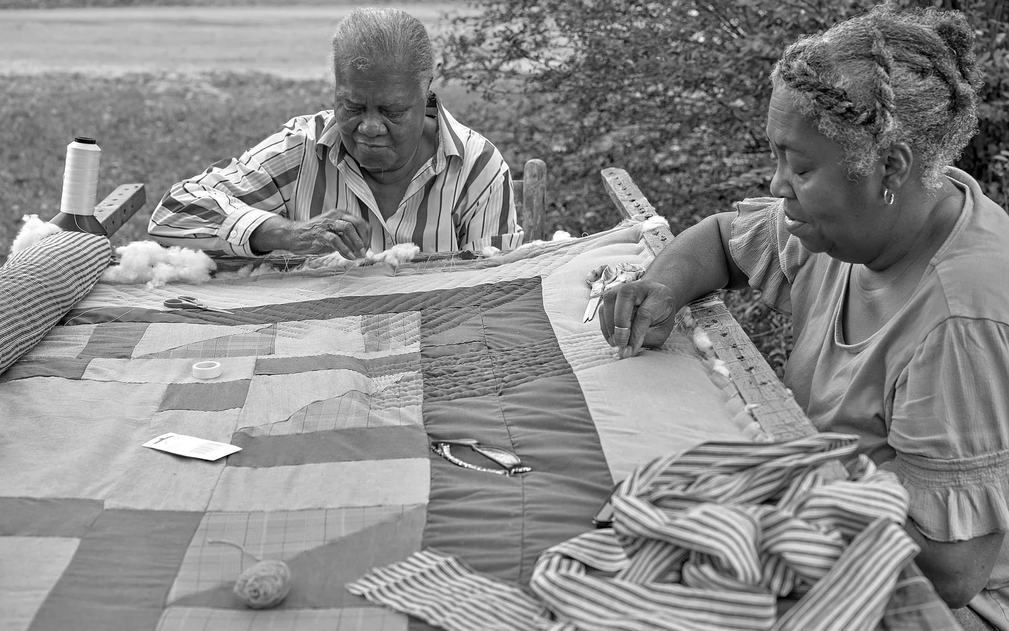 Two quilters at a frame