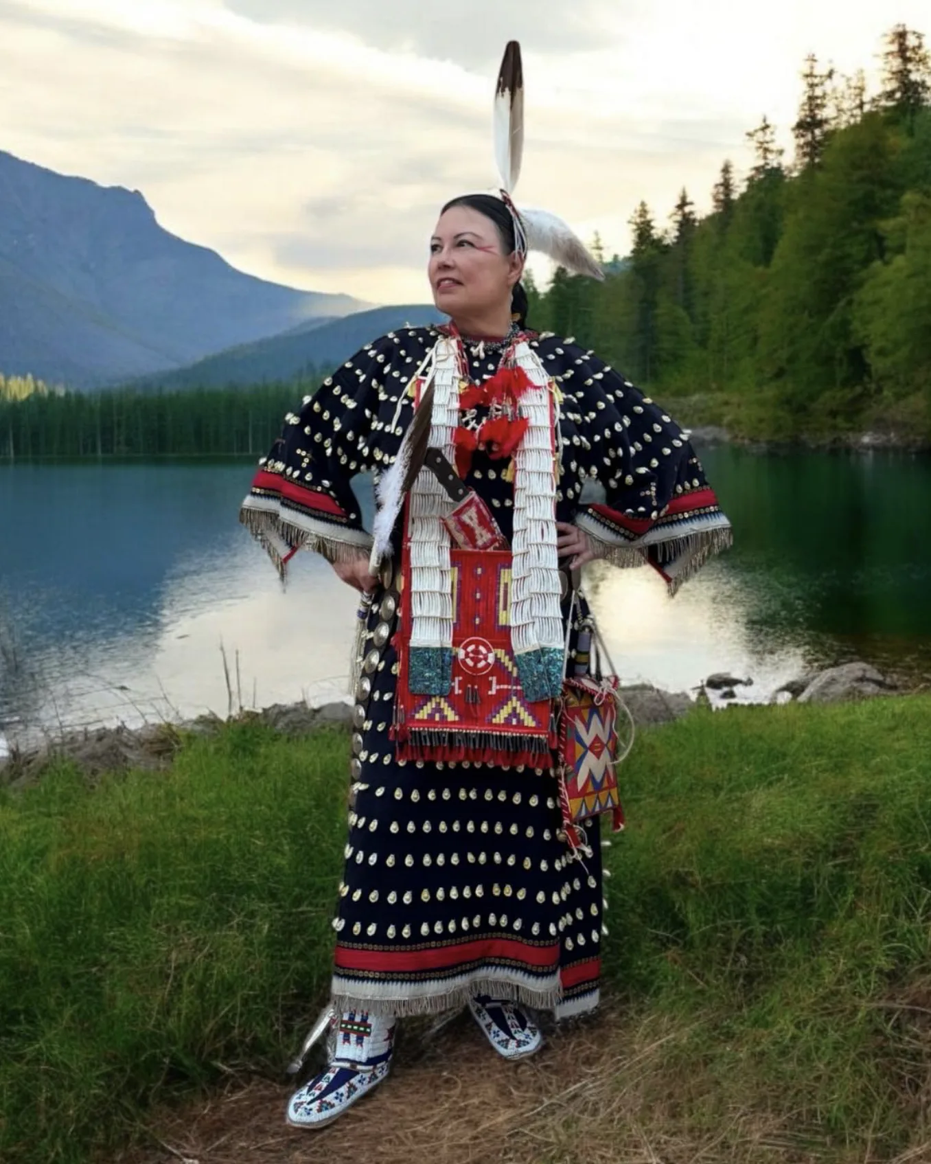Rhonda Holy Bear in beaded regalia by a lake